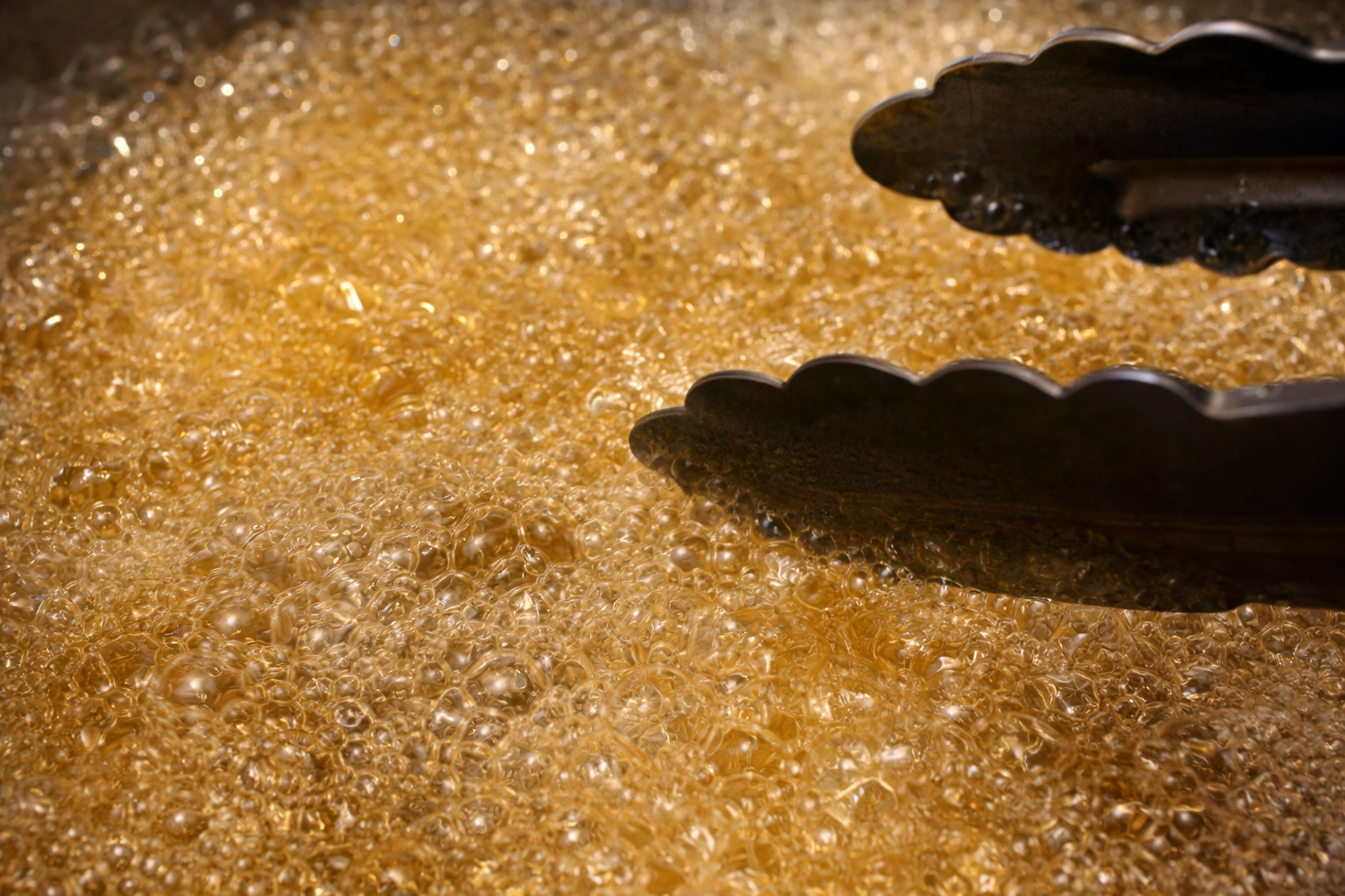 Golden prawns being deep-fried in hot oil until crispy