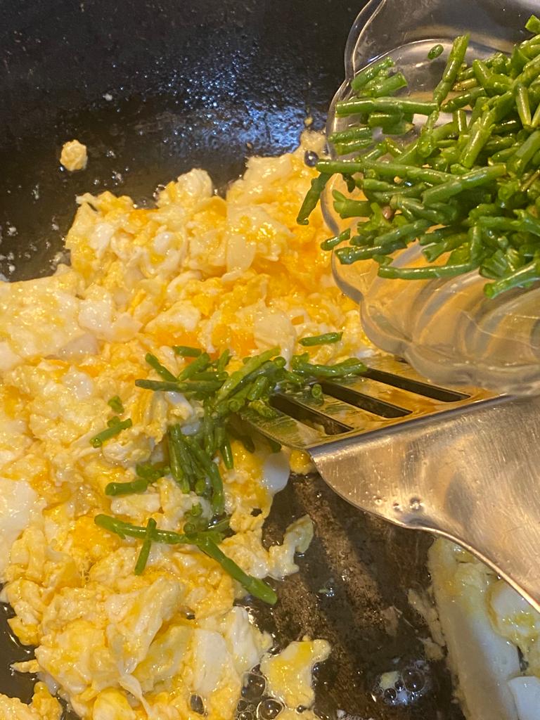 Mixed vegetables and scrambled eggs being stir-fried with samphire
