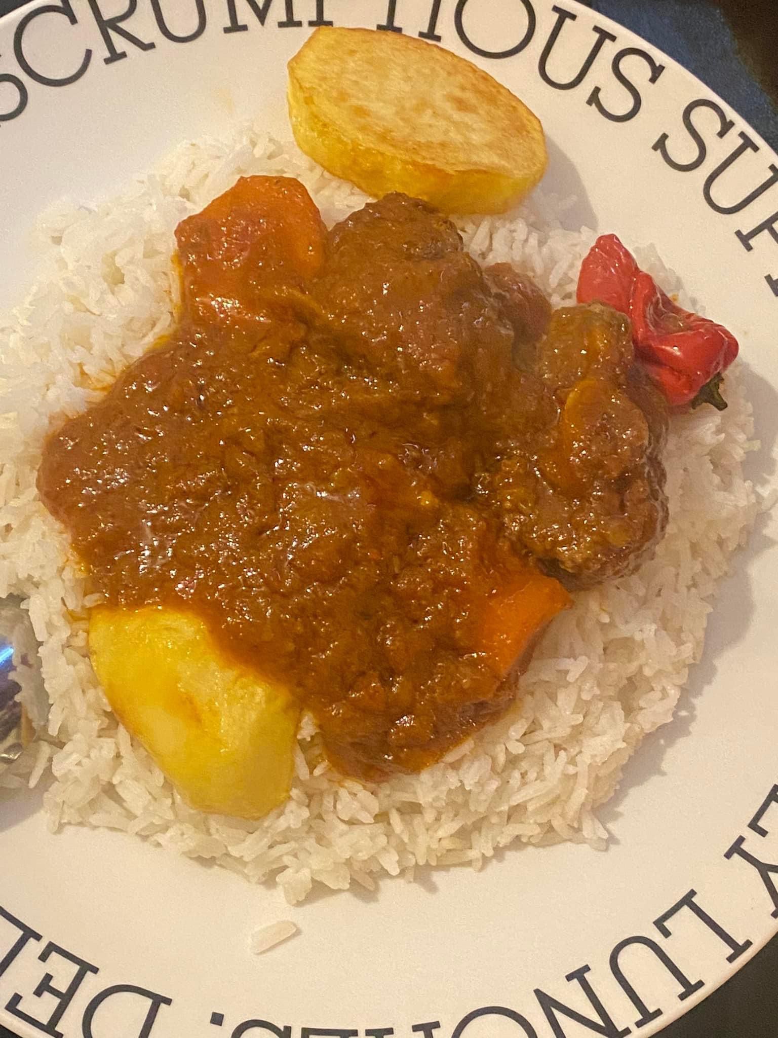 Lamb and beef stew with potatoes and carrots served over white rice