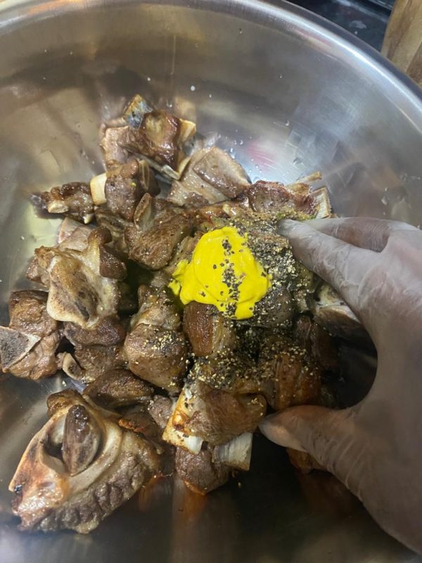  Meat pieces coated with mustard, black pepper, and seasoning paste.