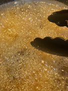 Golden prawns being deep-fried in hot oil until crispy
