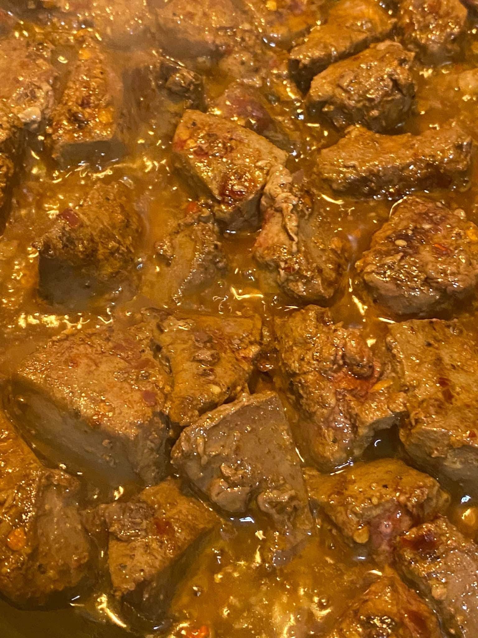 Liver slices searing in a skillet, browning with spices and juices for the Gourmet Blend recipe.