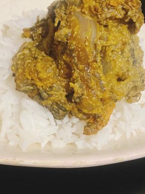 Potato Leaf Stew served over fluffy white rice on a plate