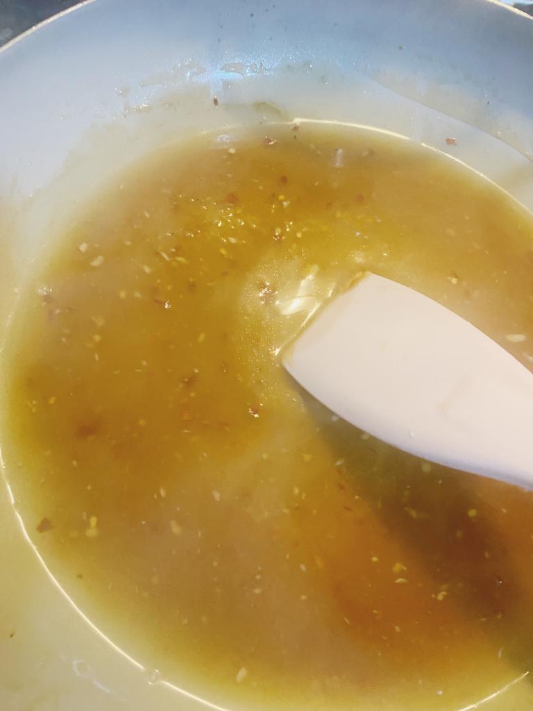 Soy sauce, oyster sauce, chili flakes, and water simmering in a pan to create a glaze for cabbage wraps