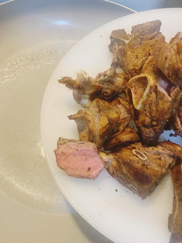 Browned lamb pieces on a plate, ready to be coated with seasoning paste.
