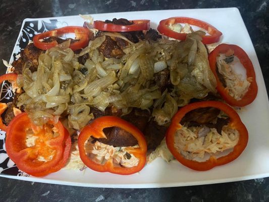Fried chicken served with creamy cabbage and carrot salad, topped with caramelized onions and red pepper rings.