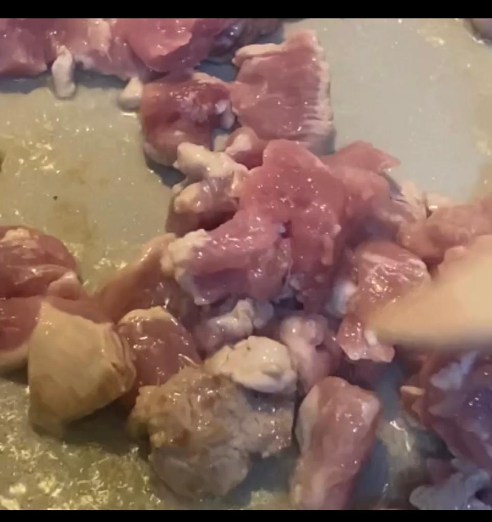Minced garlic added to meat cooking in a skillet.