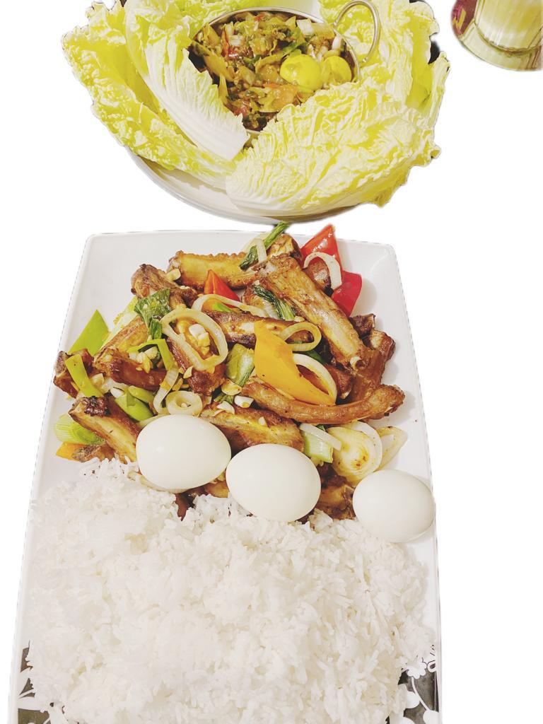 Plated stir-fry with meat, vegetables, boiled eggs, and rice served alongside a salad