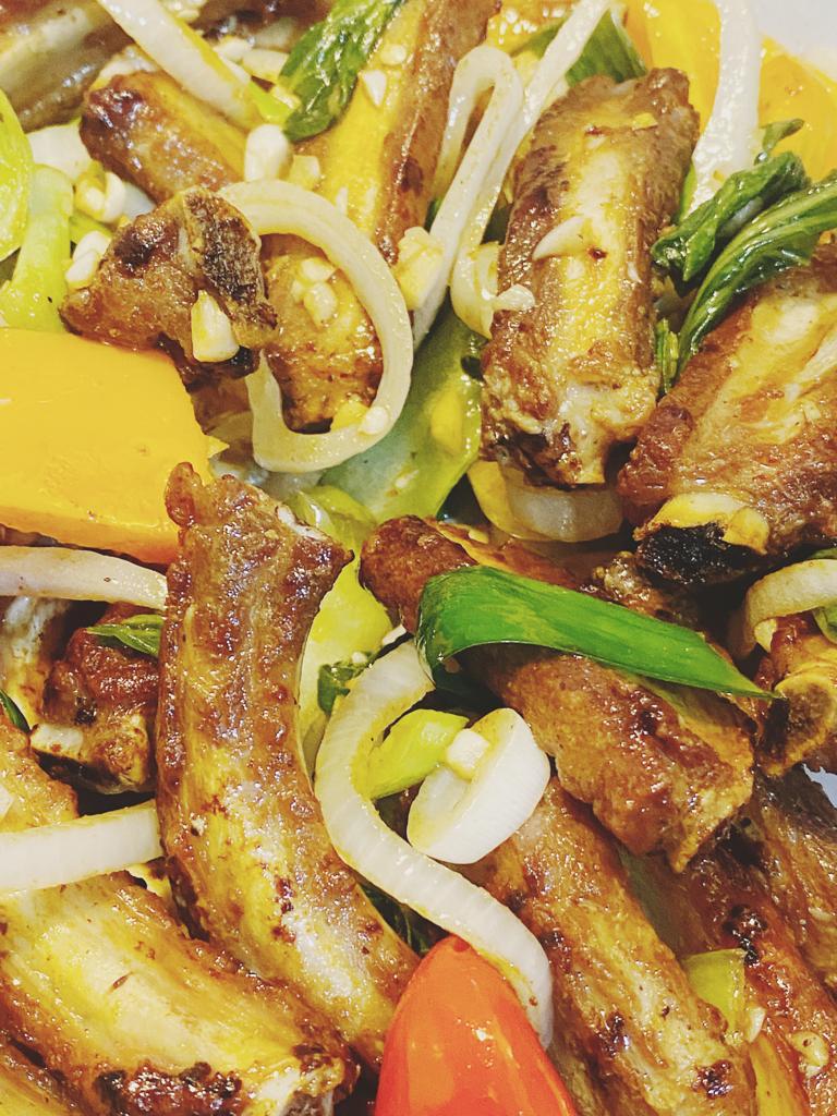 Stir-fry with meat, onions, peppers, and spring onions served on a plate