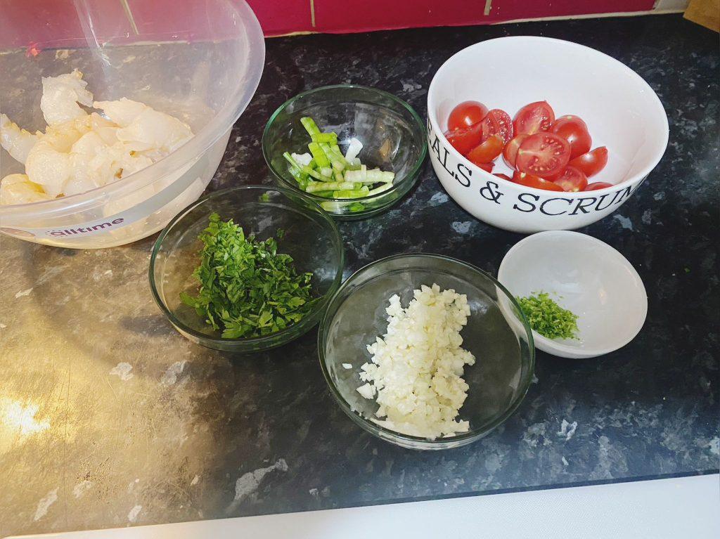 Freshly chopped tomatoes, herbs, and garlic prepared for prawn stir fry