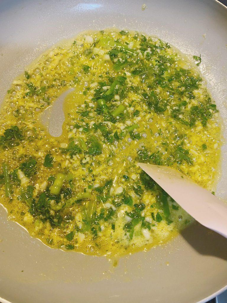 Garlic, chives, and spring onions sizzling in melted butter for stir-fry base