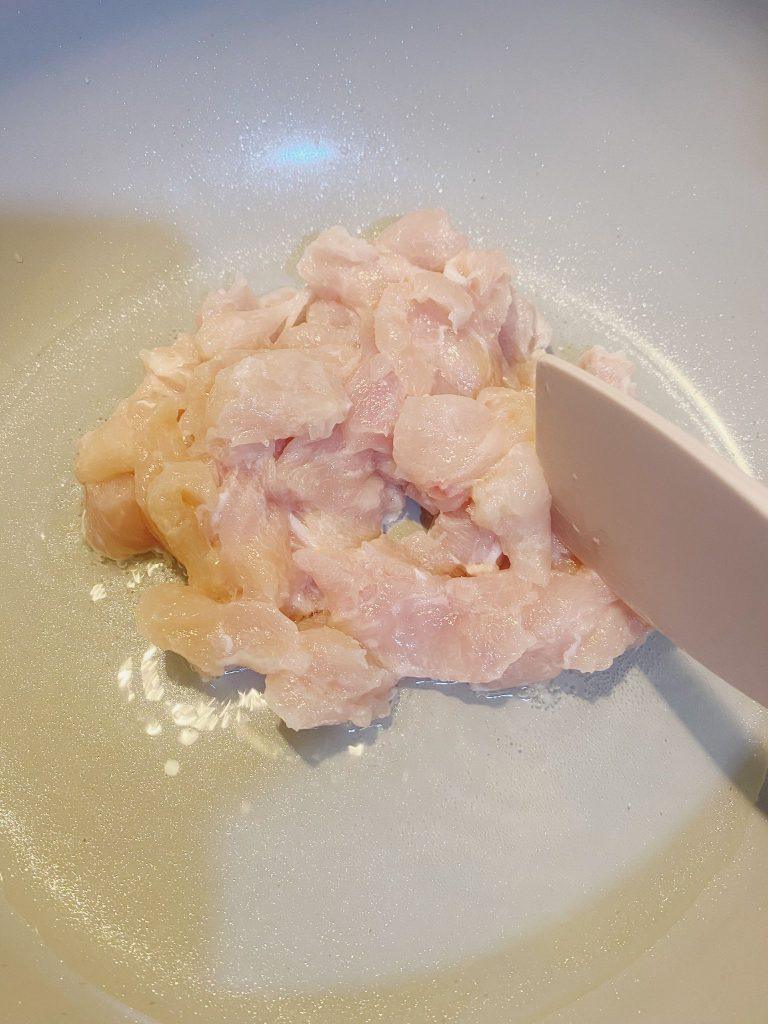 Golden brown chicken pieces sizzling in a pan with oil over medium heat.
