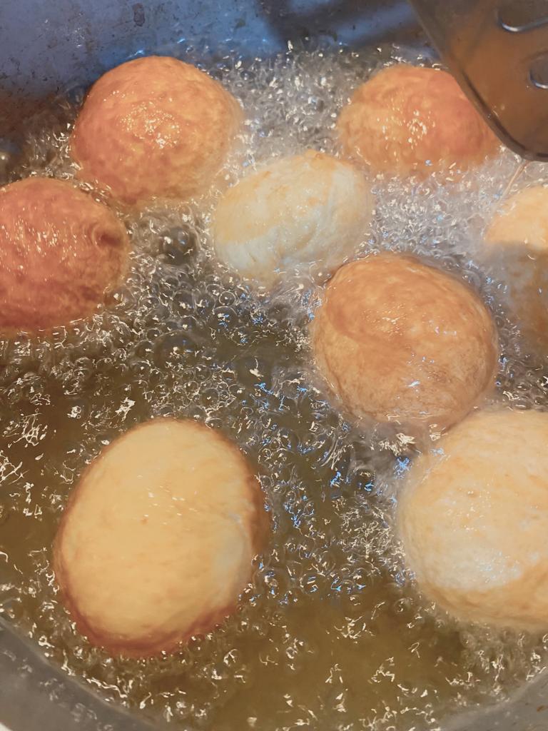 Cinnamon roll bites frying in hot oil until golden brown.