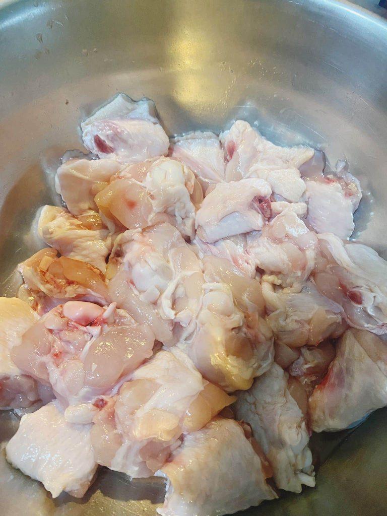 Marinated chicken wings in a bowl with soy sauce, vinegar, and salt