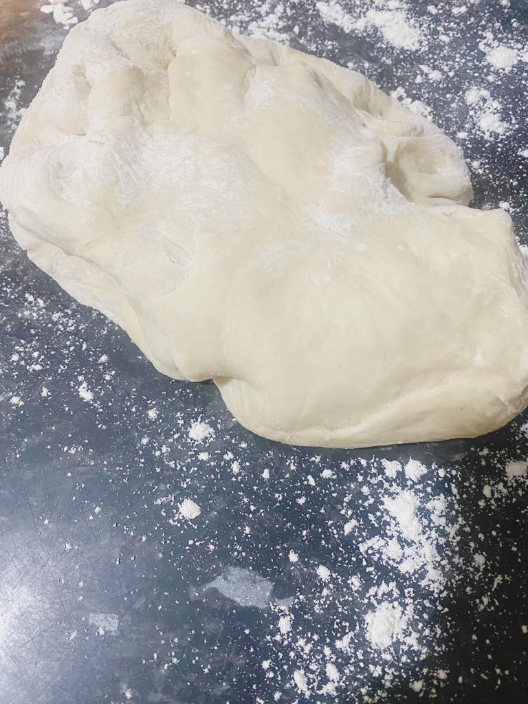 Risen dough resting on a floured surface.