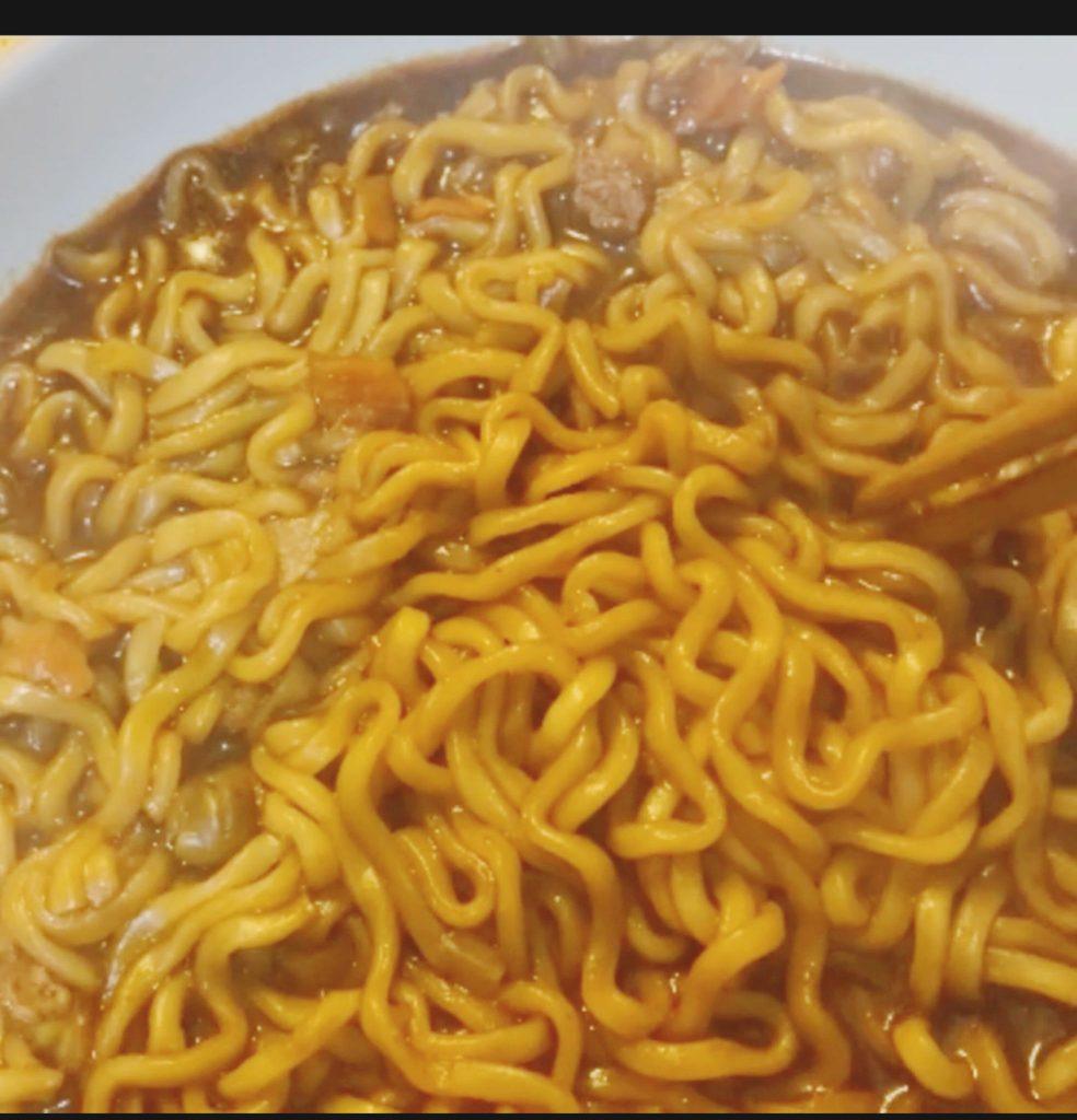 Close-up of noodles boiling in a pot, carefully monitored for a perfect al dente texture.