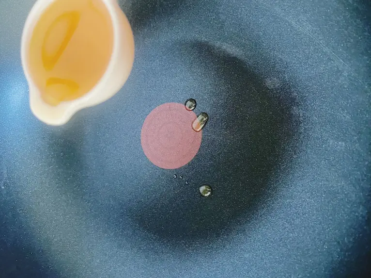 Butter is being added to a non-stick skillet before pouring in eggs for an omelette.