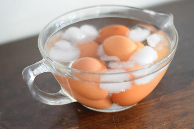 Boiled eggs cooling in a bowl of ice water for easy peeling