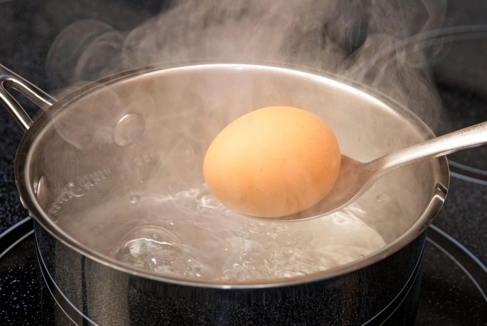 Eggs boiling in a saucepan with water on a stove