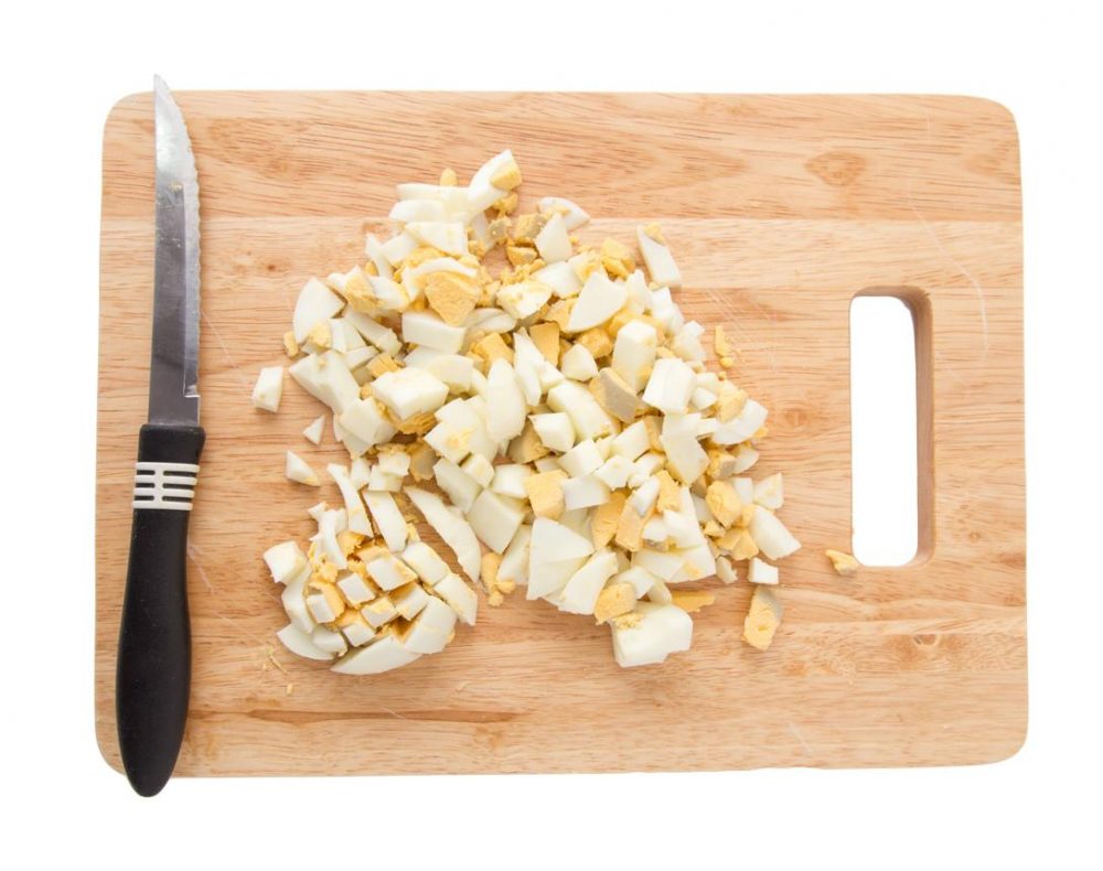 Chopped boiled eggs on a cutting board for egg and avocado toast