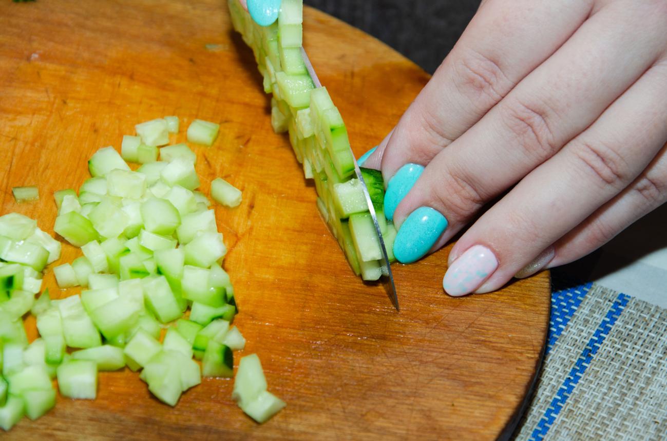 Diced cucumber cubes on a cutting board for egg and avocado toast