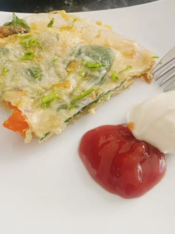Rice paper omelette served with ketchup and mayonnaise on a plate