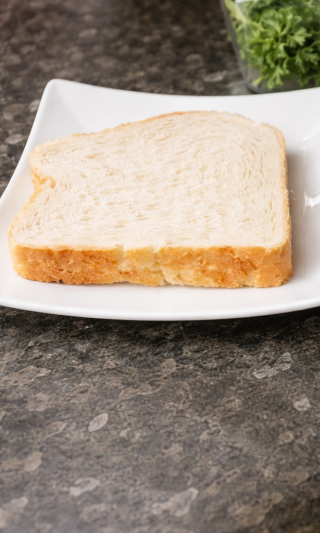White bread slice placed on a plate ready for avocado toast