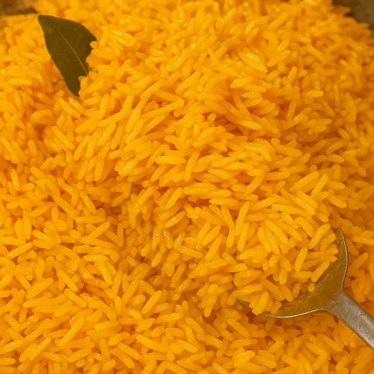 A spoon lifting fluffy rice from the pot during cooking