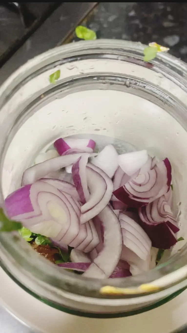 Freshly sliced red onions and chopped parsley in a glass jar, ready for marinating or seasoning