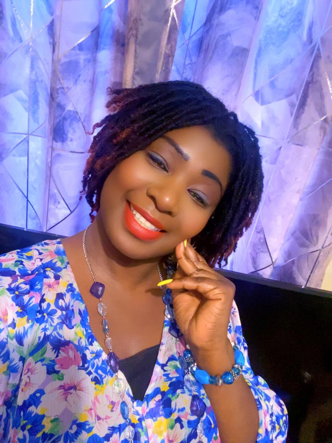 Tima Gaye smiling in blue floral outfit