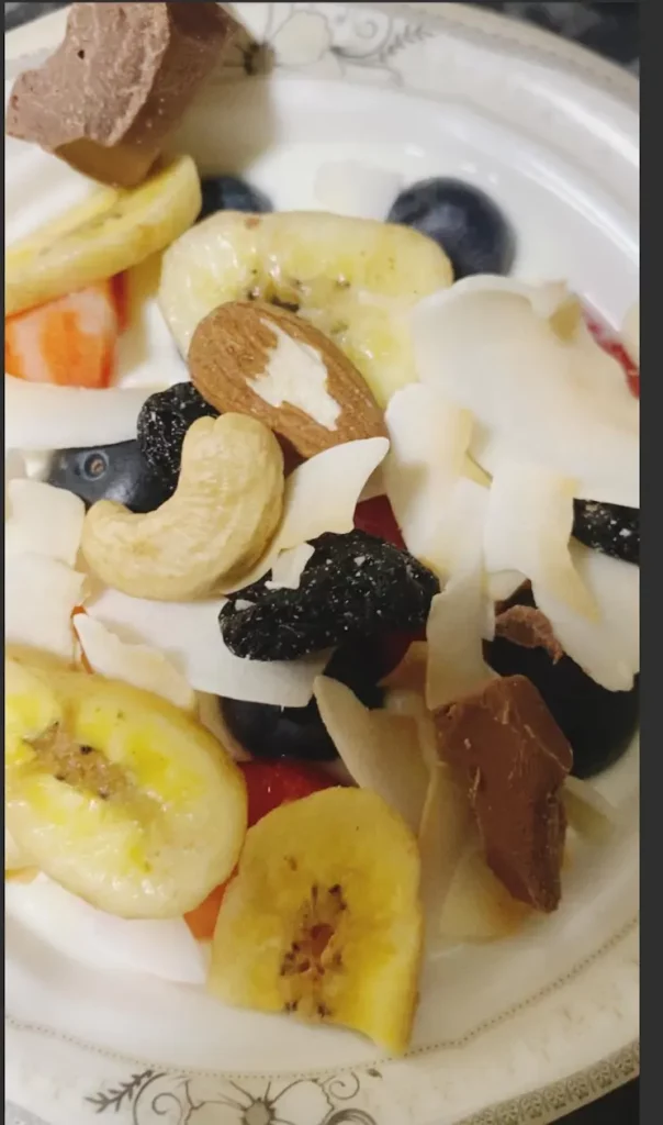 Close-up of dried fruit and nuts layered over yogurt and berries.