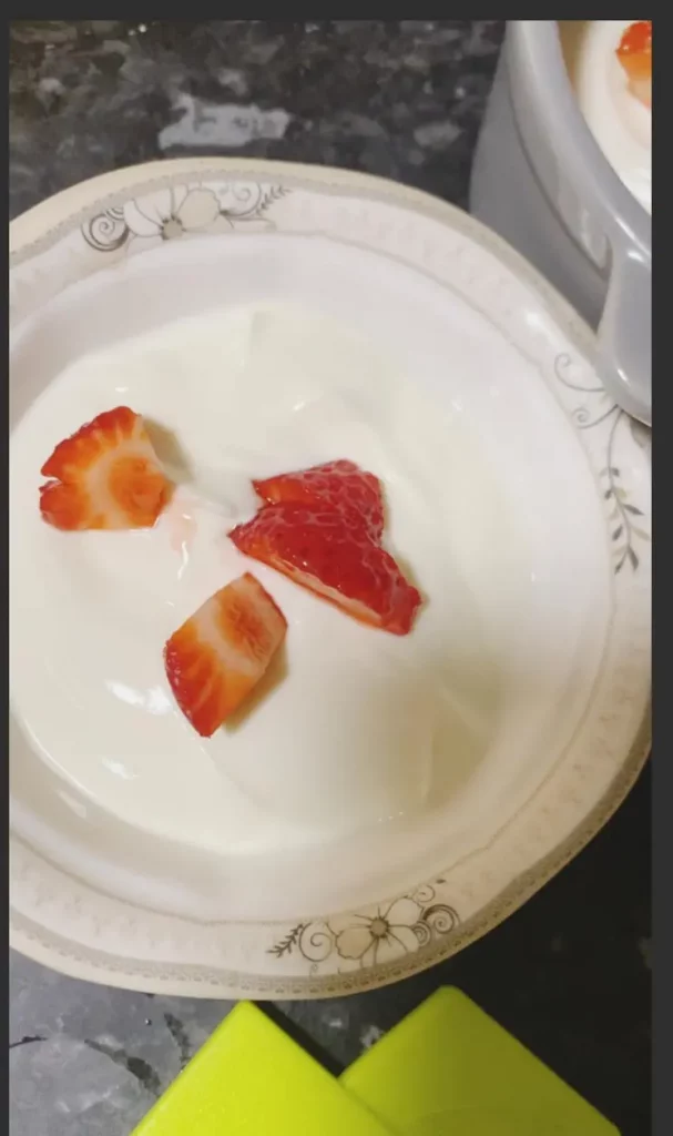 Sliced strawberries are placed on top of yogurt.