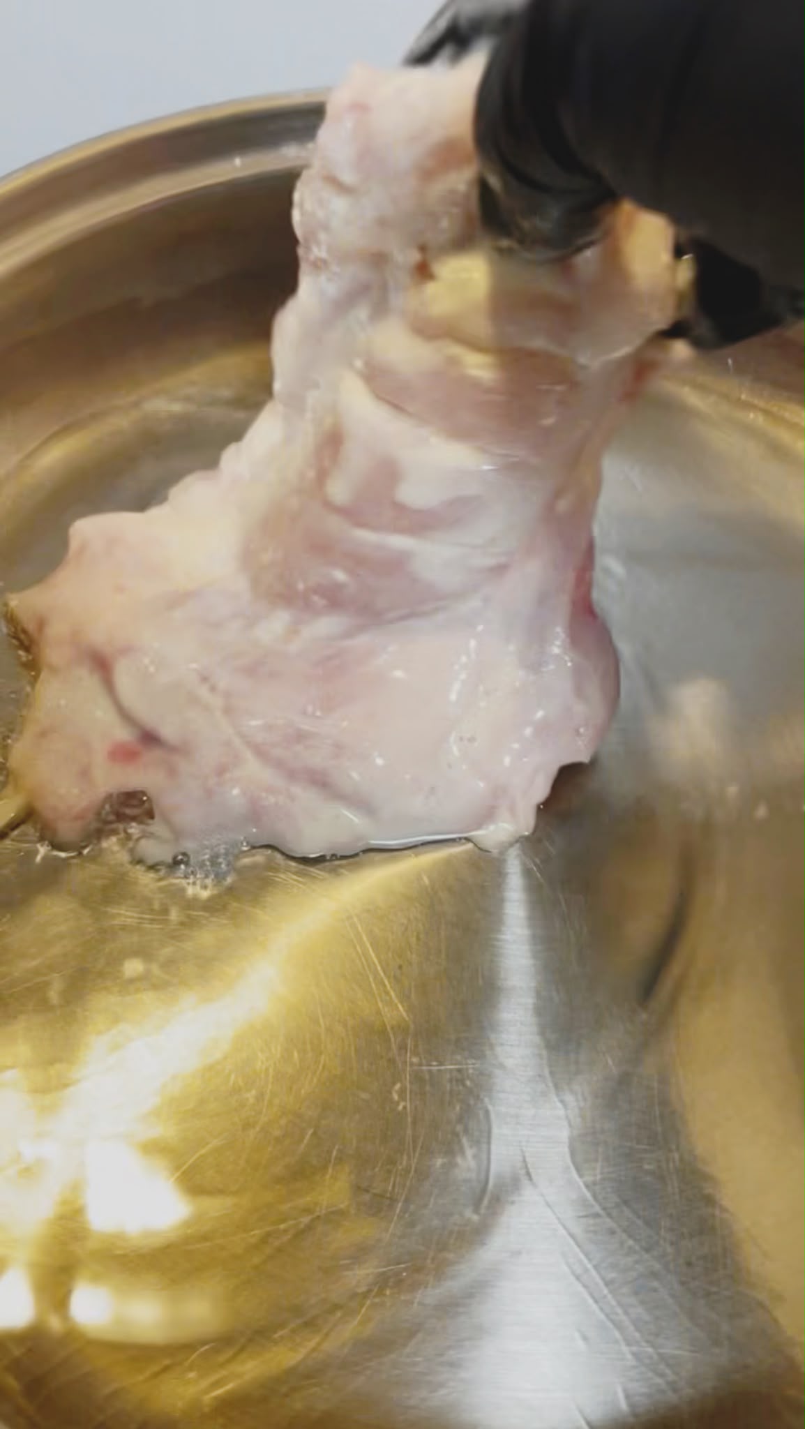 Chicken thighs frying until golden and crispy