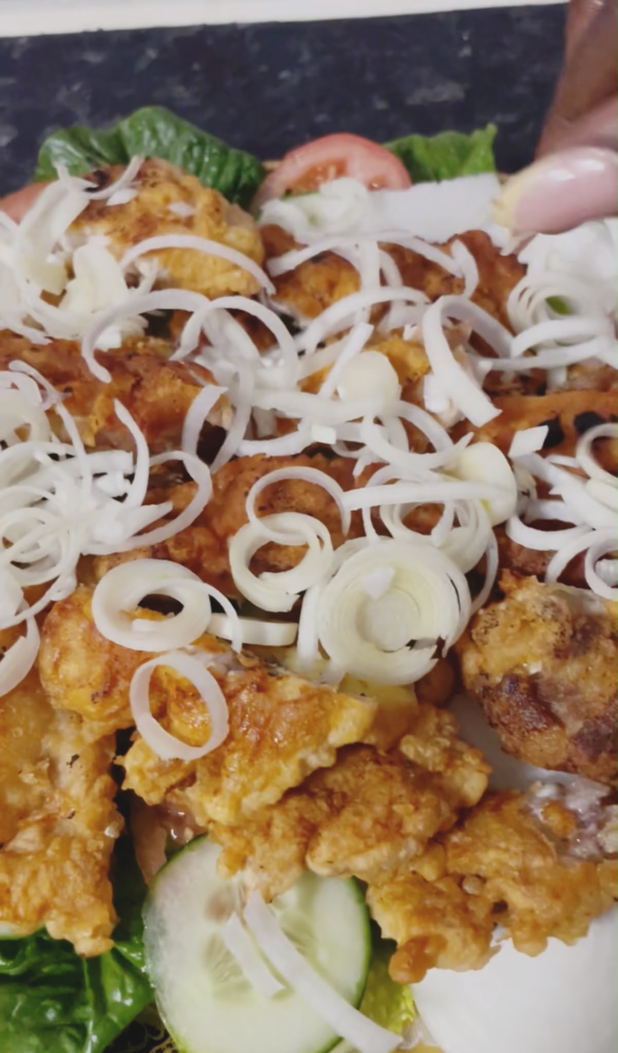 Crispy chicken and prawns arranged over fresh salad